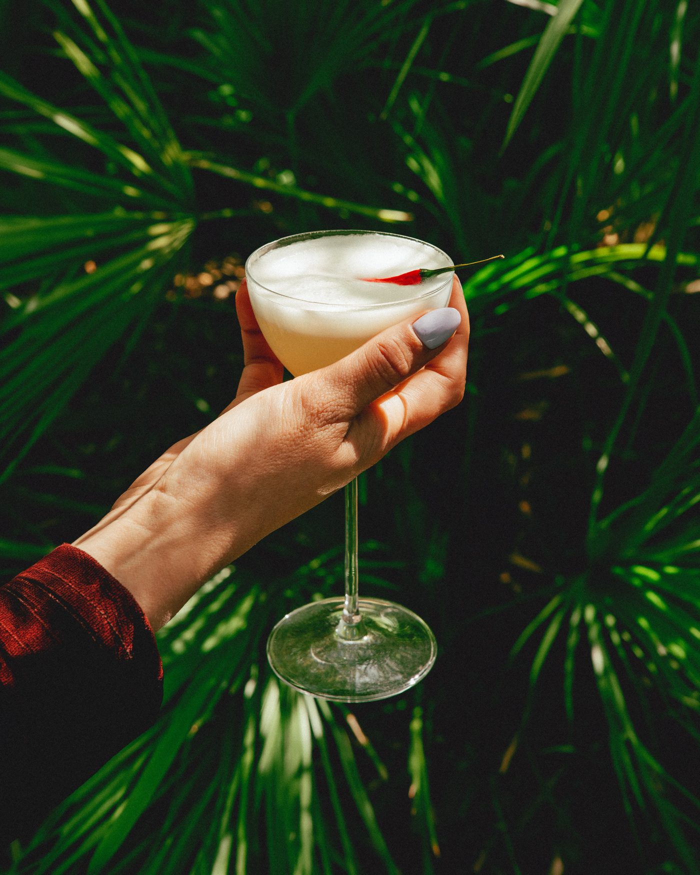 Un cocktail levé devant les palmiers du jardin de la Villa